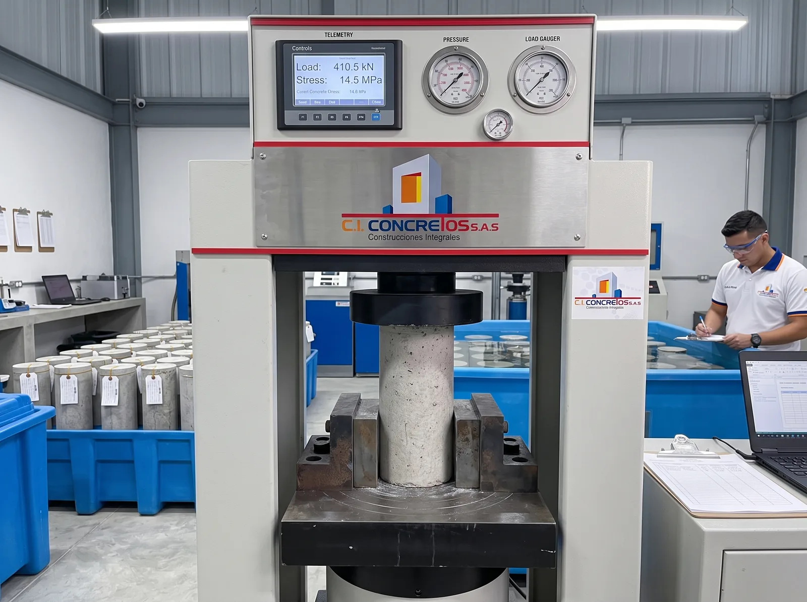 Prensa de ensayo de rotura a compresión NTC 673 con probeta de concreto y pantalla digital 410.5 kN en CI CONCRETOS